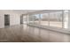 Sunlit living area featuring wood-look floors, large windows offering backyard views, and an open layout at 1628 E Sunland Ave, Phoenix, AZ 85040