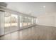 Bright living room with sliding door access, wood-look floors, and multiple large windows at 1628 E Sunland Ave, Phoenix, AZ 85040