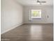 Bright living room with wood-look floors, a ceiling fan, and a large window at 1628 E Sunland Ave, Phoenix, AZ 85040