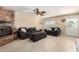A well-lit living room featuring a brick fireplace, tile flooring, and comfortable seating area at 1733 W Surrey Ave, Phoenix, AZ 85029