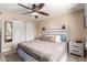 This main bedroom has light walls, wood flooring, a ceiling fan, and a bed with bedside tables at 1733 W Surrey Ave, Phoenix, AZ 85029
