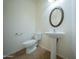 Half bathroom with a pedestal sink, oval mirror, and tile floors provides convenience for guests at 17433 W Holland Ln, Surprise, AZ 85388