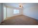 Spacious carpeted bedroom with a ceiling fan and window providing natural light at 17433 W Holland Ln, Surprise, AZ 85388