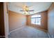 Bedroom with neutral carpeting, a ceiling fan, a curved window, and tan walls creates a relaxing space at 17433 W Holland Ln, Surprise, AZ 85388