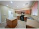Well-lit kitchen featuring tile flooring, black appliances, wooden cabinets, and a convenient center island at 17433 W Holland Ln, Surprise, AZ 85388