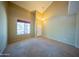 Bright living room featuring a tile and carpet, high ceilings, and a large window at 17433 W Holland Ln, Surprise, AZ 85388