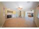 Open-concept living room with tile floors, a cozy fireplace, and seamless access to the kitchen at 17433 W Holland Ln, Surprise, AZ 85388