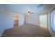 Main bedroom featuring neutral carpet, natural light, a ceiling fan, and ensuite bath and closet space creates an oasis at 17433 W Holland Ln, Surprise, AZ 85388