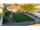 This backyard features easy-to-care desert landscaping, artificial grass, a small garden, and a covered patio at 17706 N Rosa Dr, Maricopa, AZ 85138