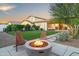 Backyard with artificial turf, desert landscaping, fire pit and covered patio at 17706 N Rosa Dr, Maricopa, AZ 85138