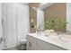 Modern bathroom with a double vanity, white countertops, and a shower with a white curtain at 17706 N Rosa Dr, Maricopa, AZ 85138