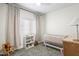 Calm Bedroom with a white crib, gray-patterned curtains, and plenty of soft, natural light at 17706 N Rosa Dr, Maricopa, AZ 85138