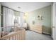 Charming Bedroom with soft green walls, a crib, rocking chair, and delicate paper lantern lighting at 17706 N Rosa Dr, Maricopa, AZ 85138