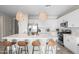Spacious kitchen featuring a large island with seating, white cabinets, stainless steel appliances, and modern pendant lighting at 17706 N Rosa Dr, Maricopa, AZ 85138