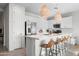Well-lit kitchen boasts white cabinets, stainless steel appliances, a central island with seating, and modern pendant lights at 17706 N Rosa Dr, Maricopa, AZ 85138