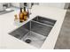 Close-up of a modern kitchen sink featuring a double basin, stylish faucet, and countertop soap dispensers at 17706 N Rosa Dr, Maricopa, AZ 85138