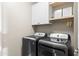 Laundry room with modern washer and dryer, complemented by cabinets and shelving at 17706 N Rosa Dr, Maricopa, AZ 85138