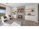 Comfortable living room features a fireplace, decorative shelving, modern furniture and bright natural light at 17706 N Rosa Dr, Maricopa, AZ 85138