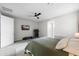 Bright bedroom featuring a ceiling fan, television and exercise equipment at 17706 N Rosa Dr, Maricopa, AZ 85138