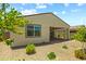 A neutral-colored home's backyard features drought resistant landscaping, window and covered patio at 18032 W Muirwood Dr, Goodyear, AZ 85338