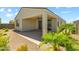 Backyard featuring a covered patio, palm trees, and rock landscaping at 18032 W Muirwood Dr, Goodyear, AZ 85338