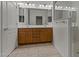 Bright bathroom with a double sink vanity, large mirrors, and a glass enclosed shower at 18032 W Muirwood Dr, Goodyear, AZ 85338