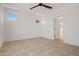Bright bedroom featuring a ceiling fan, tile flooring and a doorway to the bathroom at 18032 W Muirwood Dr, Goodyear, AZ 85338