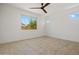 Well-lit bedroom featuring a ceiling fan and large window with natural light at 18032 W Muirwood Dr, Goodyear, AZ 85338