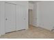 Bedroom featuring a closet with paneled doors and neutral flooring at 18032 W Muirwood Dr, Goodyear, AZ 85338