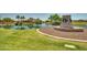 Scenic view of a serene pond with lush landscaping and manicured lawns creating a tranquil and inviting community space at 18032 W Muirwood Dr, Goodyear, AZ 85338