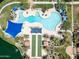Overhead view of the pool with lounge chairs, shade umbrellas, and a bocce ball court, set in a lush, green landscape at 18032 W Muirwood Dr, Goodyear, AZ 85338