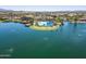 An aerial view of the community pool with lake and desert community in the distance at 18032 W Muirwood Dr, Goodyear, AZ 85338