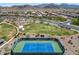 Aerial view of a tennis court, showcasing the park's recreational options and community spaces with beautiful mountain backdrop at 18032 W Muirwood Dr, Goodyear, AZ 85338