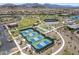Aerial view of multiple tennis and pickleball courts near community park and a bocce ball court for active lifestyles at 18032 W Muirwood Dr, Goodyear, AZ 85338