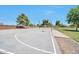 Outdoor basketball court featuring a well-maintained surface, hoops, and benches surrounded by mature shade trees at 18118 N Smith Dr, Maricopa, AZ 85139