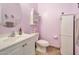 Bright bathroom featuring white fixtures, decorative wall art and plants, and complementary pale purple wall paint at 18118 N Smith Dr, Maricopa, AZ 85139