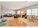 Large living room featuring hardwood floors, carpet, multiple sofas, and large windows with blinds at 18118 N Smith Dr, Maricopa, AZ 85139