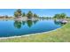 Picturesque pond with mature shade trees and lush green grass; the perfect place for a relaxing stroll at 18118 N Smith Dr, Maricopa, AZ 85139
