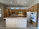 Kitchen with light wood cabinets, an island and modern white appliances at 20609 N 57Th Dr, Glendale, AZ 85308