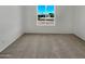 Simple bedroom with neutral carpet and a large window that provides natural light and a view of the neighborhood at 2127 W Marco Polo Rd, Phoenix, AZ 85027