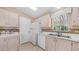 Bright kitchen features white appliances, countertops, and cabinetry with light wood-look flooring at 2400 E Baseline Ave # 197, Apache Junction, AZ 85119