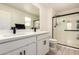 Bright bathroom featuring dual sinks with black faucets and a glass-enclosed shower at 25539 W Gwen St, Buckeye, AZ 85326
