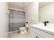Clean bathroom featuring a white vanity, black hardware and a shower with a striped curtain at 25539 W Gwen St, Buckeye, AZ 85326
