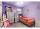 Purple bedroom featuring a twin bed, matching dresser, and decorations on the wall at 25539 W Gwen St, Buckeye, AZ 85326
