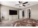 Bedroom featuring gray walls, ceiling fan, large dresser with TV, and a walk-in closet at 25539 W Gwen St, Buckeye, AZ 85326