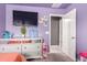 Bedroom featuring a dresser with TV, and playful decorations on the lavender painted walls at 25539 W Gwen St, Buckeye, AZ 85326