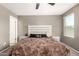 Neutral bedroom featuring a cozy bed with a plush brown blanket and a white-washed headboard at 25539 W Gwen St, Buckeye, AZ 85326