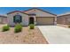 Inviting single-story home featuring a two-car garage, neutral stucco, a desert landscape, and a charming covered entry at 25539 W Gwen St, Buckeye, AZ 85326