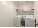 Laundry room with two white appliances and a shelf, showcasing a functional space at 25539 W Gwen St, Buckeye, AZ 85326