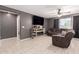 Cozy living room with a fireplace, tile floors, a ceiling fan, and comfortable seating at 25539 W Gwen St, Buckeye, AZ 85326